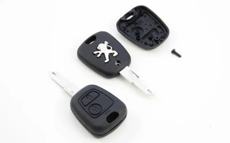 Llave de Peugeot despiezada: el espadín, el mando y la placa electrónica por separado